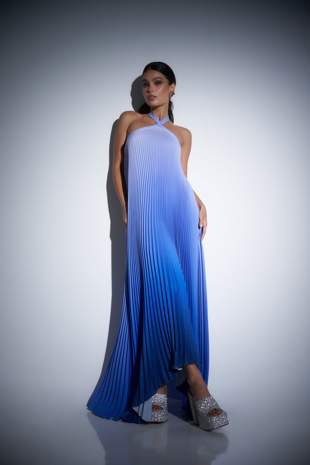 Model in a blue gradient pleated dress.