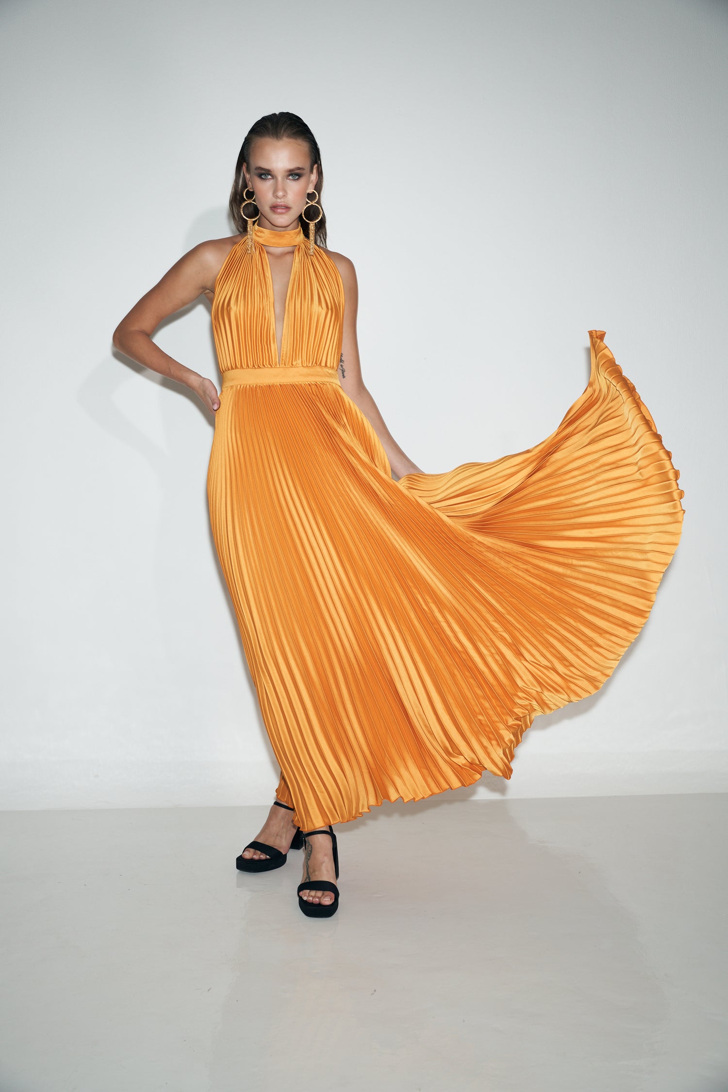 Model in an orange pleated dress