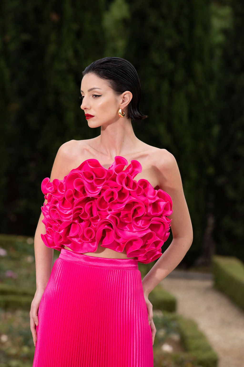 A woman dressed in a pink outfit with a floral top