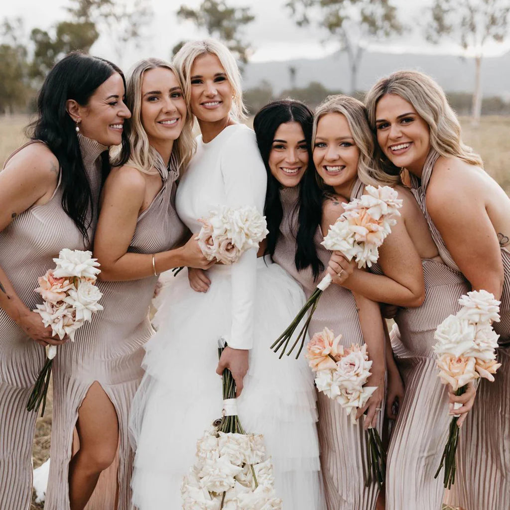 Bridal party wearing matching dresses, each holding a lovely bouquet of flowers.